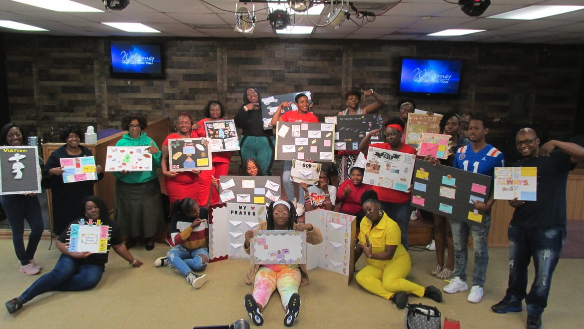 Members holding the vision boards they created together inside the church